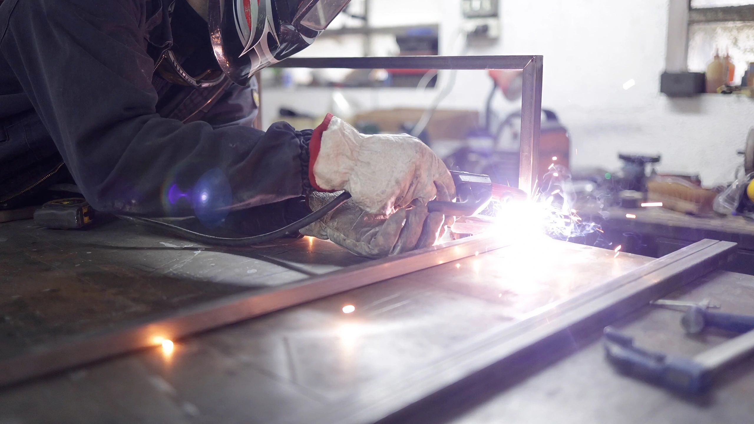Electric arc welding on a metal frame with bright sparks