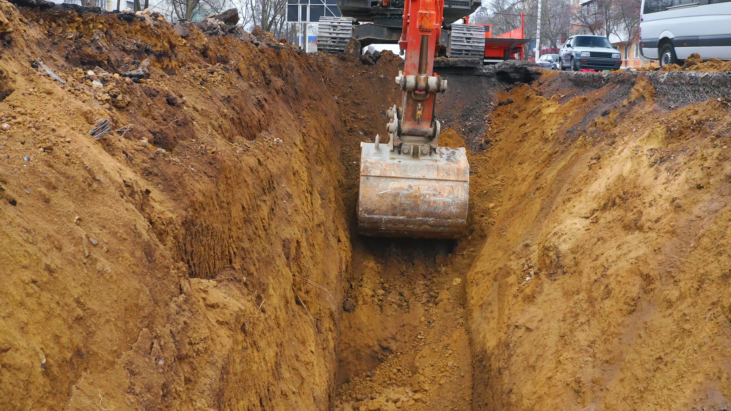 Excavator digging a trench for site and drainage preparation