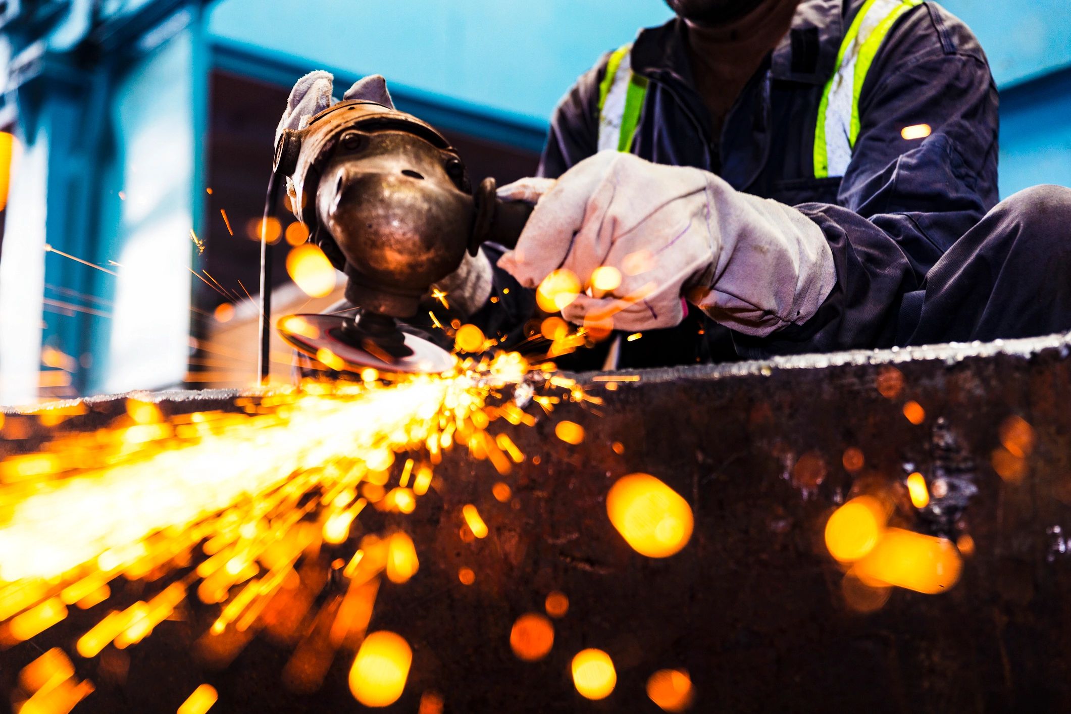 Factory worker grinding metal to a polished finish